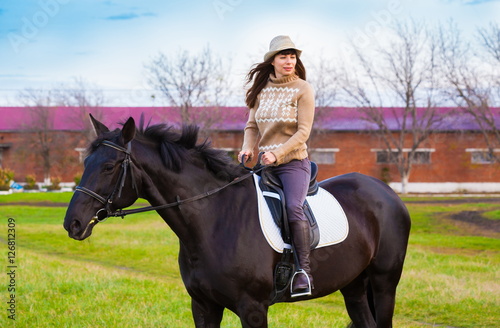  Woman riding horse, beige pullover, jeans, hat, close up