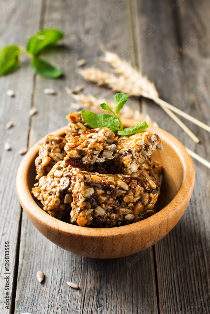 Roasted nuts and sunflower seeds in caramel and sugar in bamboo bowl on the old wooden background. Selective focus. Roasted nuts and sunflower seeds in caramel and sugar in bamboo bowl on the old wooden background. Selective focus.