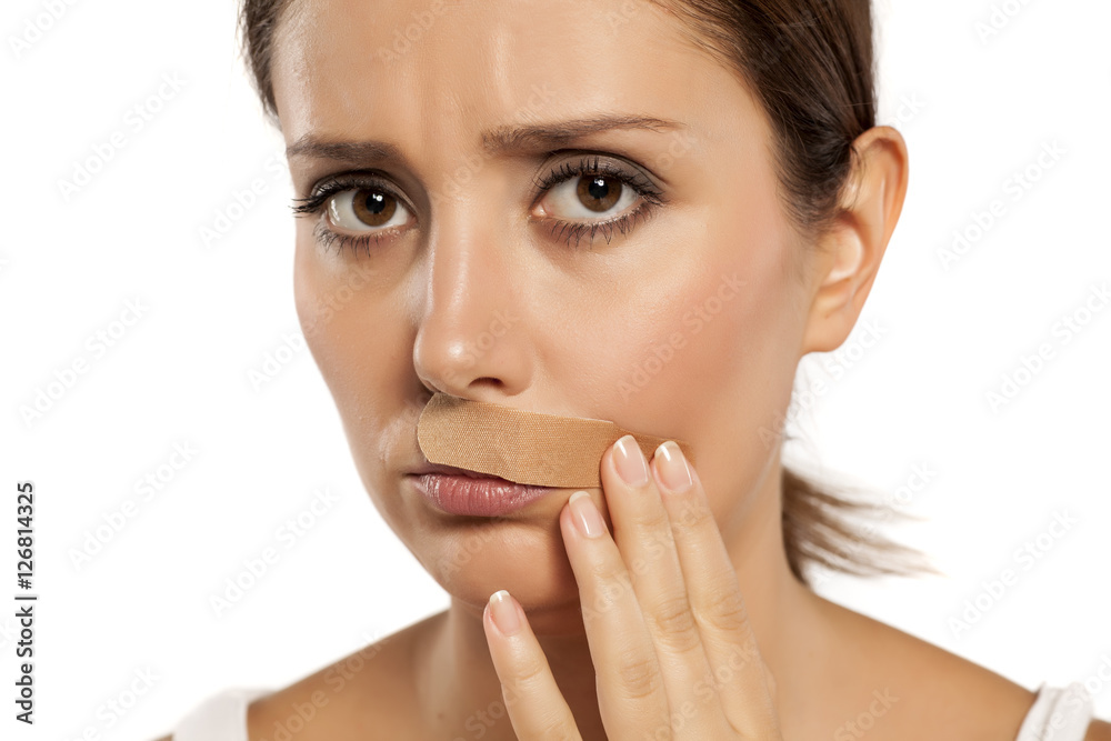 sad woman with sticking plaster for first-aid on her mustache sad woman with sticking plaster for first-aid on her mustache