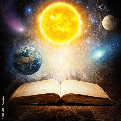 Opened magic book with sun, earth, moon, saturn, stars and galaxy. Concept on the topic of astronomy or fantasy. Elements of this image furnished by NASA.