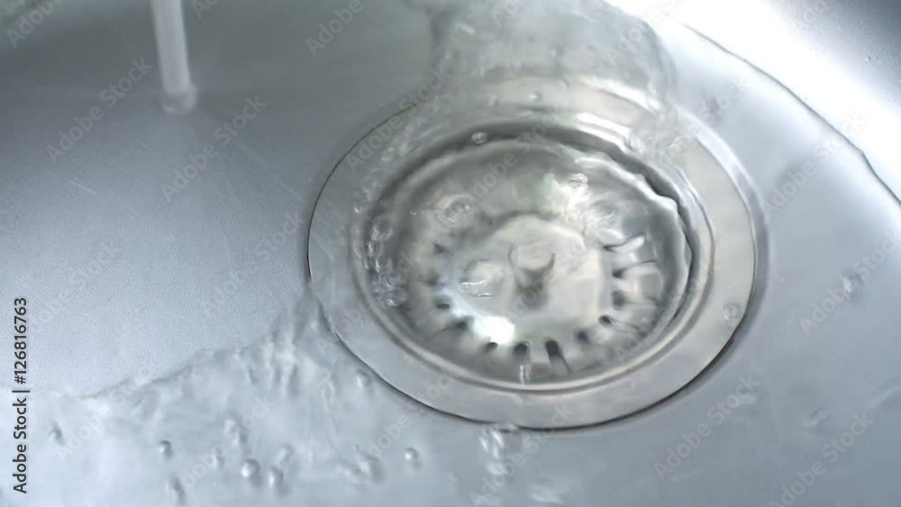 Drain the water in a steel sink in the kitchen. 4k Drain the water in a steel sink in the kitchen. 4k
