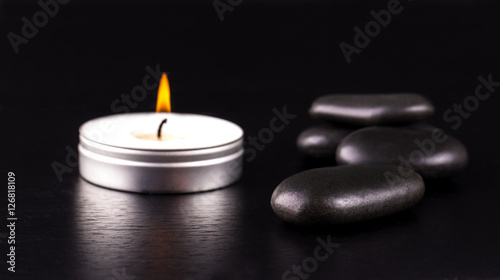 black stones and a candle on black  background