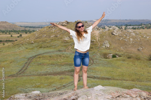 Girl on a mountain on the background of the steppe.