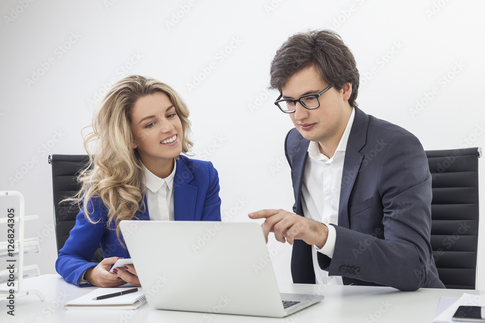Guy wearing glasses is pointing at computer screen with his coll Guy wearing glasses is pointing at computer screen with his coll