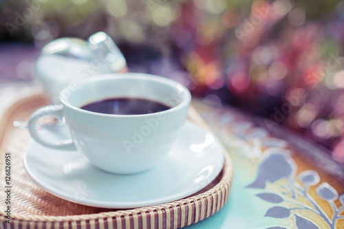 Coffee cup on vintage table against bokeh background. Vintage color style.
