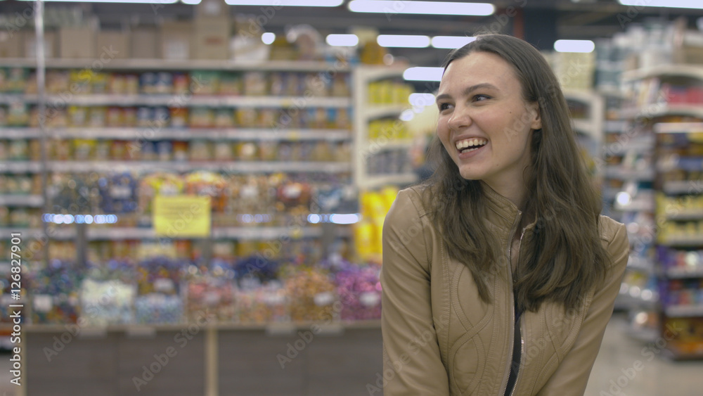 Happy girl standing in the supermarket