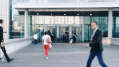 Businessmen crowd near the entry into the business center. People going to work. Concept for finance,  job and economy. Modern buildings in business district. Action by day. Focus blur. Toned