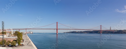 Lisbon, Portugal - October 31, 2016: The 25 de Abril bridge spanning over the Tagus River seen from the Belem District. On the right it’s seen the famous the Cristo-Rei Sanctuary.