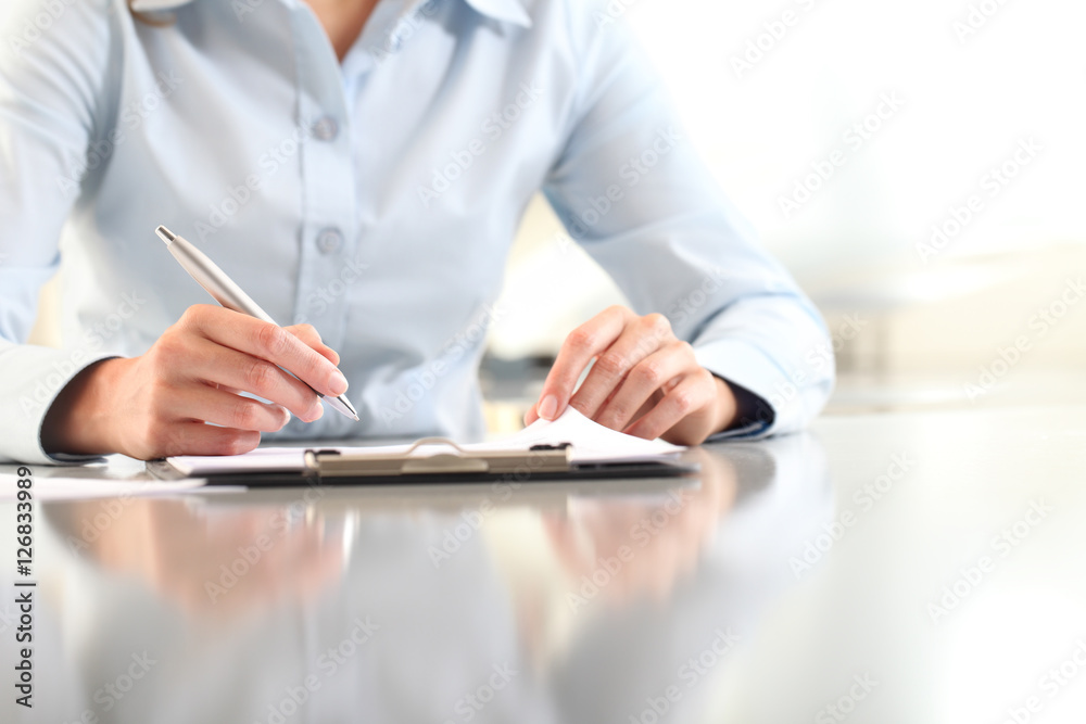woman hands writing on clipboard with a pen, isolated on desk - obrazy, fototapety, plakaty 