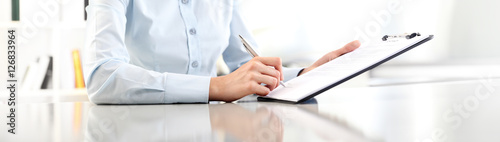 woman hands writing on clipboard with a pen, isolated on desk panoramic