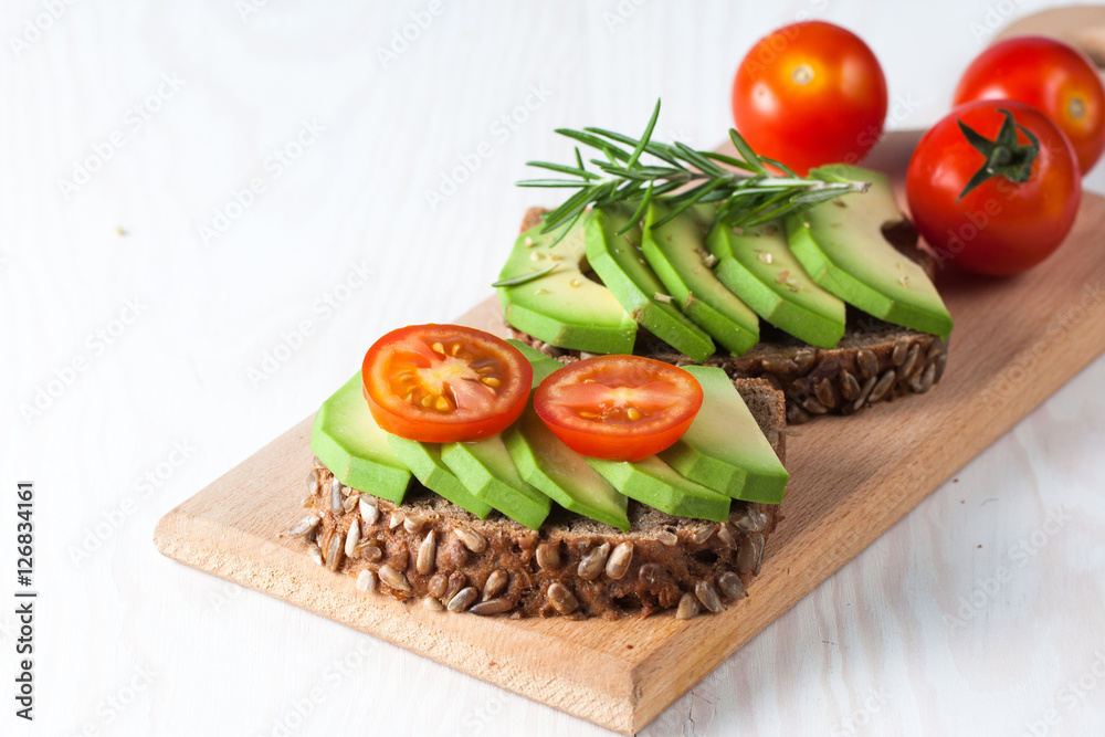 Avocado toast, cherry tomato on wooden background. Breakfast with toast avocado, vegetarian food, healthy diet concept. Avocado toast, cherry tomato on wooden background. Breakfast with toast avocado, vegetarian food, healthy diet concept.