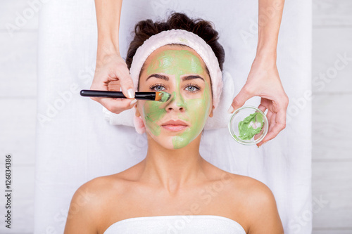 Young woman in a spa with algae facial mask. Woman in spa salon photo