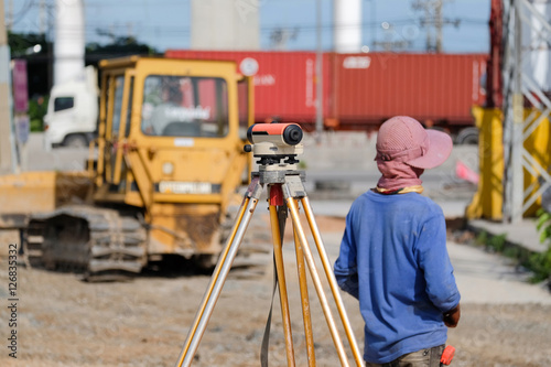 Surveyor equipment tacheometer or theodolite outdoors at construction road against worker blur background © tanasan
