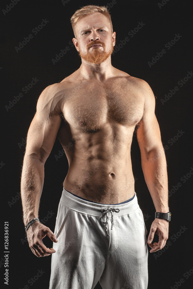 Fototapeta premium sexy brutal muscular bearded man isolated on black background