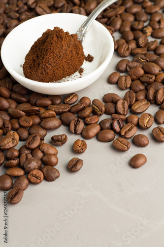 ground coffee, coffee beans and gray background