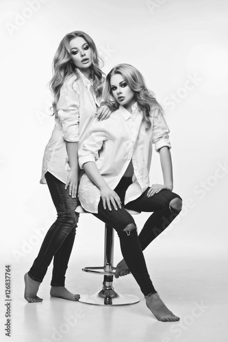 Two beautiful girls in white shirts and jeans