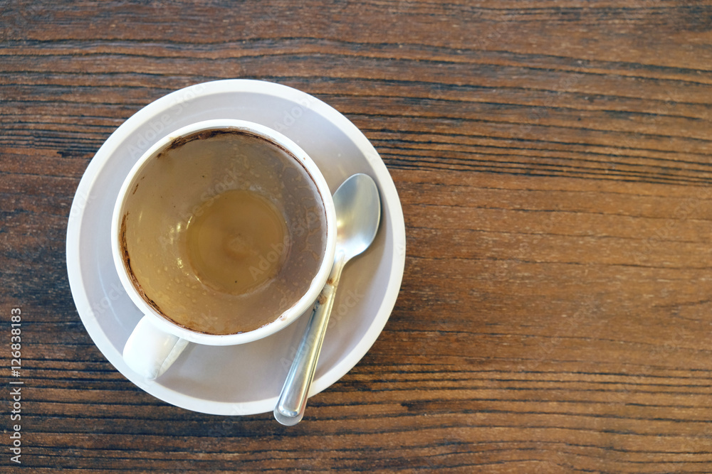 Empty coffee cup after drink on wood table in vintage tone