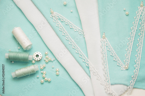 the thread, the beads, the lace are on the turquoise fabric
