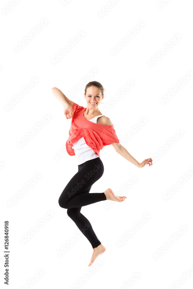 Cheerful, athletic girl jumping and looking into the camera. Isolated.