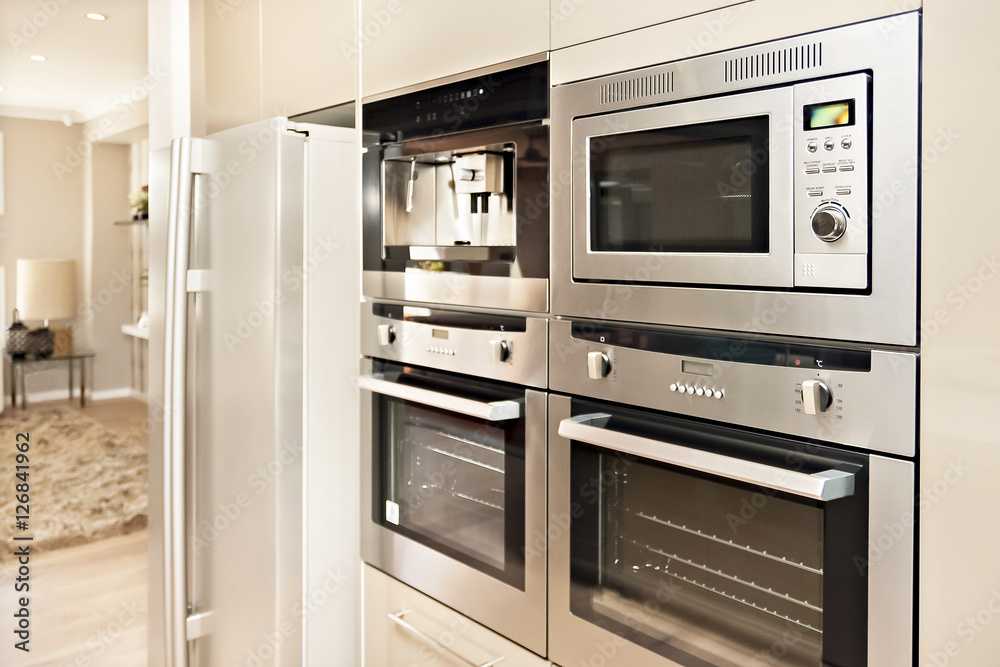 Modern oven and refrigerator fixed to the wall with pantry Modern oven and refrigerator fixed to the wall with pantry