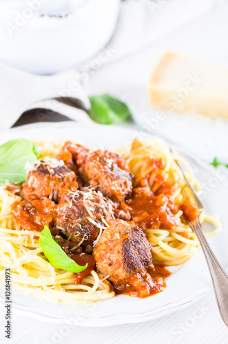 Hearty spaghetti with meatballs in tomato sauce photo