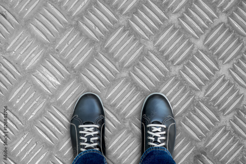 Black casual shoes standingon stainless steel floor