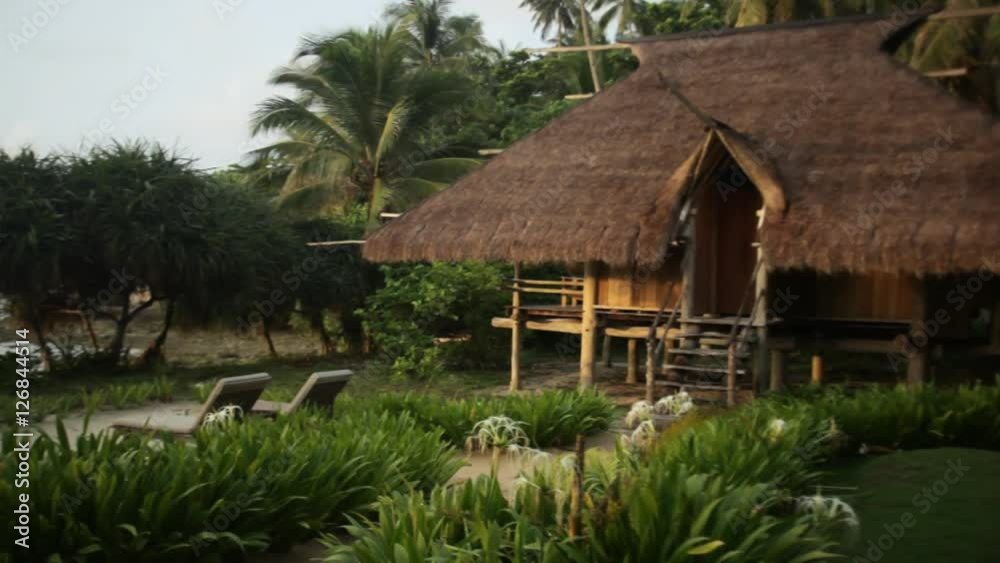 WS PAN Thatched villa surrounded by plants / Indonesia WS PAN Thatched villa surrounded by plants / Indonesia