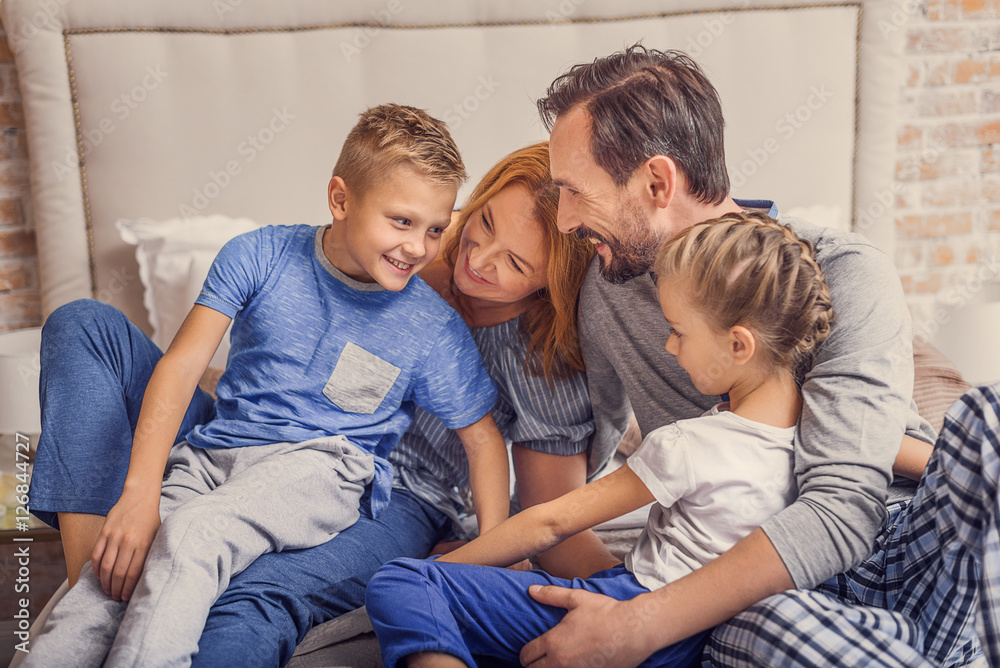 Happy family lying down on bed at home Happy family lying down on bed at home