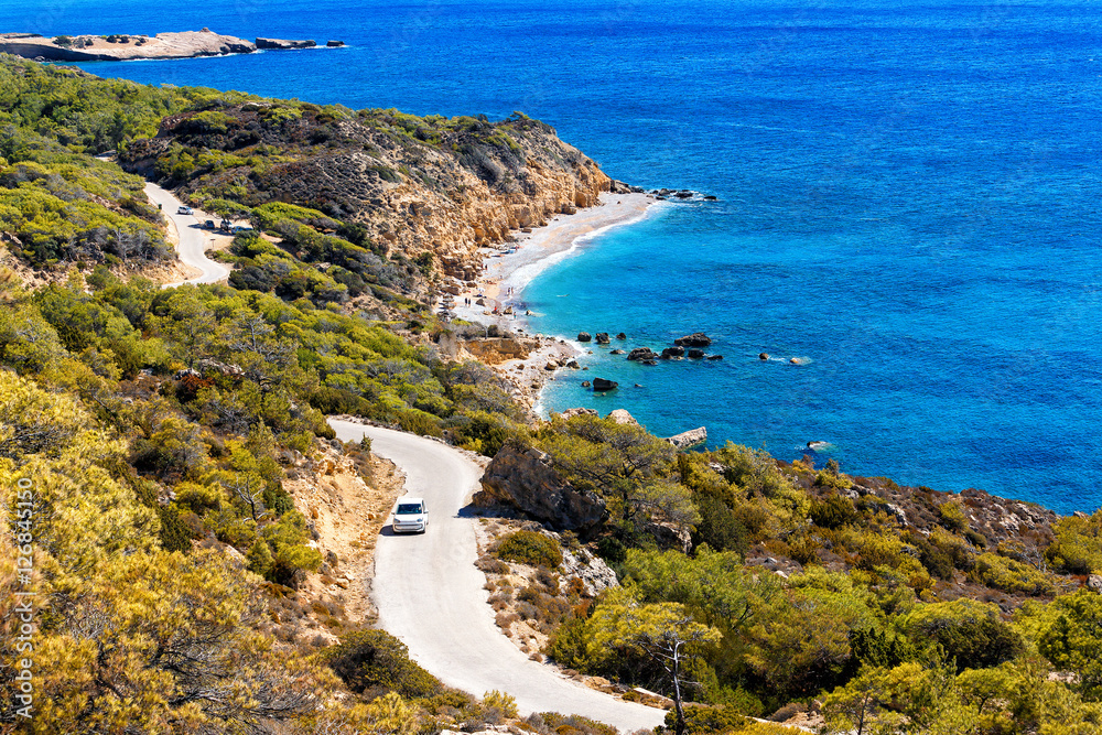 Obraz premium top view of lagoon island Rhodes, with a winding road and the car on it