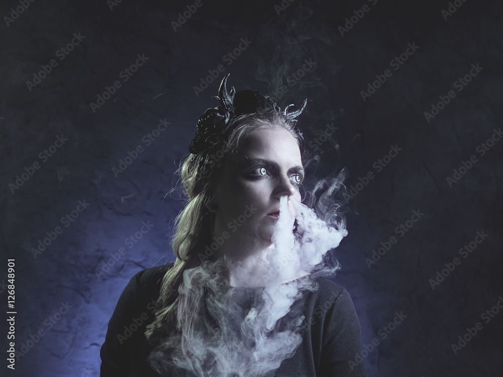 Dark portrait of evil witch in smoke