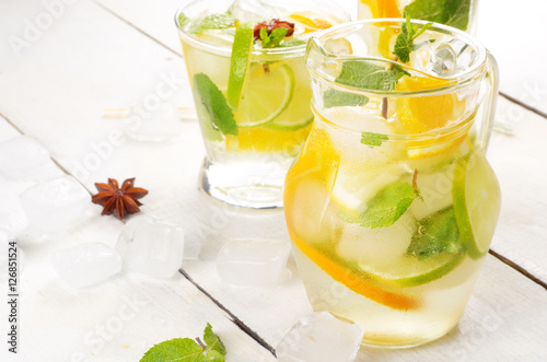 Jug with Lime and Orange Fruit Water with ice photo