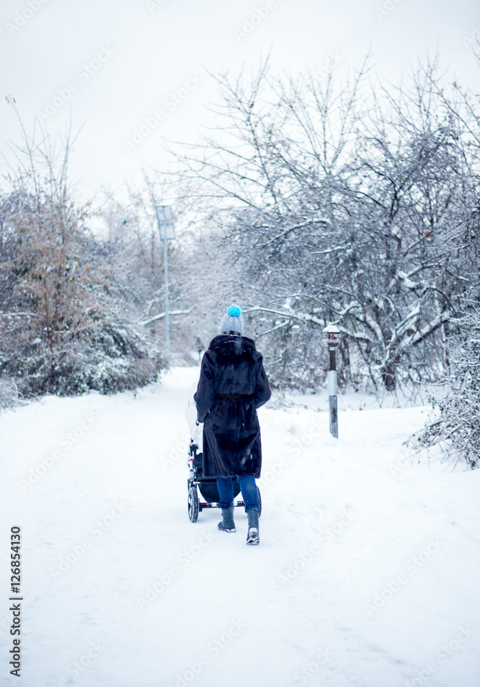 Woman with pram walking in winter