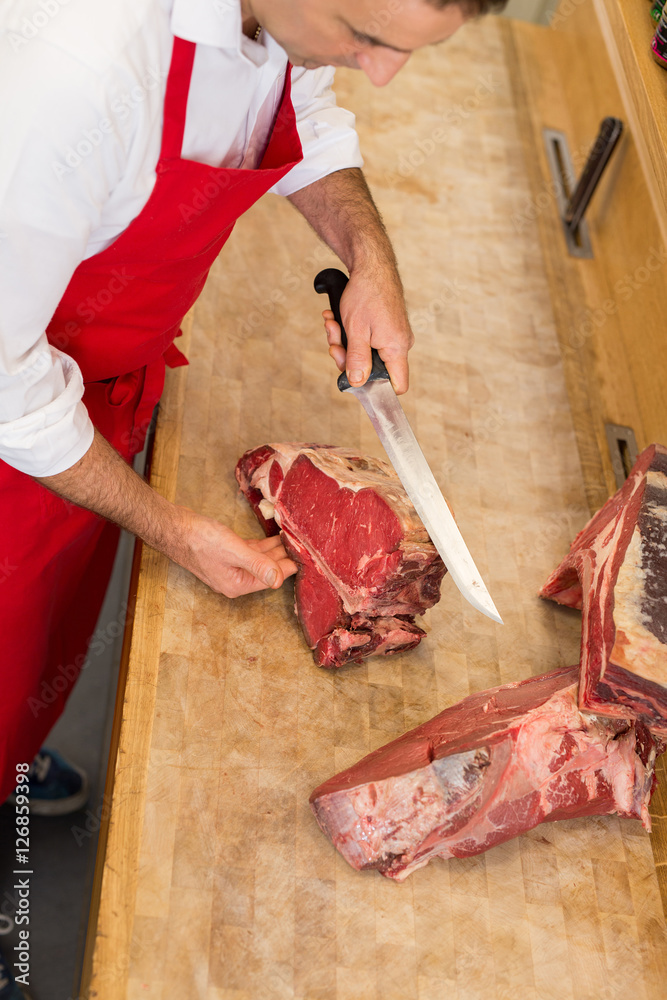 Butcher Cutting Meat At Counter high angle