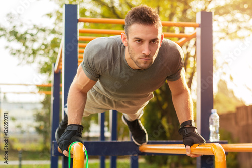 Push-ups - fitness man training push up outside in summer.