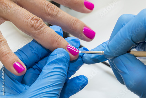 Woman doing manicure beauty salon varnish wellness