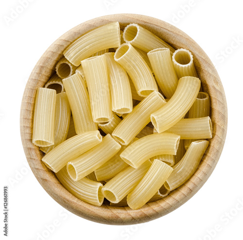 Penne rigate pasta in wooden bowl. Uncooked dried durum wheat semolina