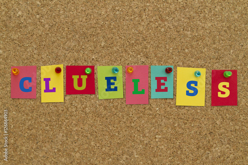 Clueless word written on colorful sticky notes pinned on cork board.