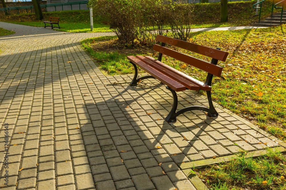 Bench in autumnal park in small polish city Bench in autumnal park in small polish city