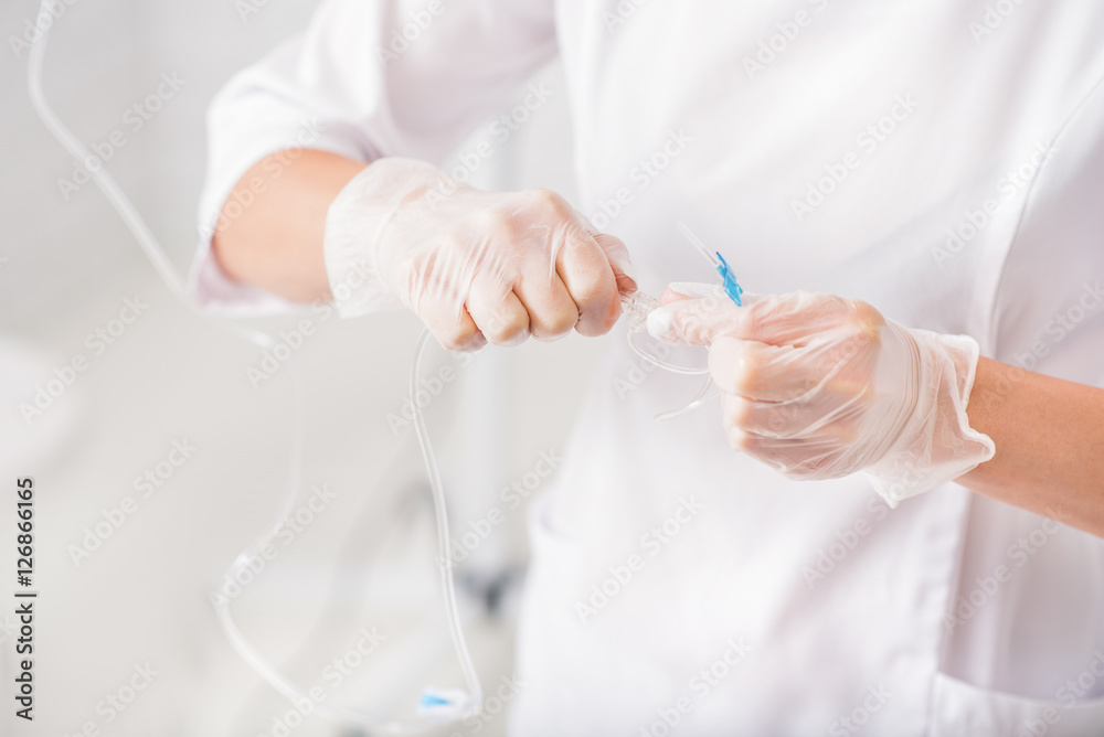 Skillful anesthesiologist putting dropper in clinic