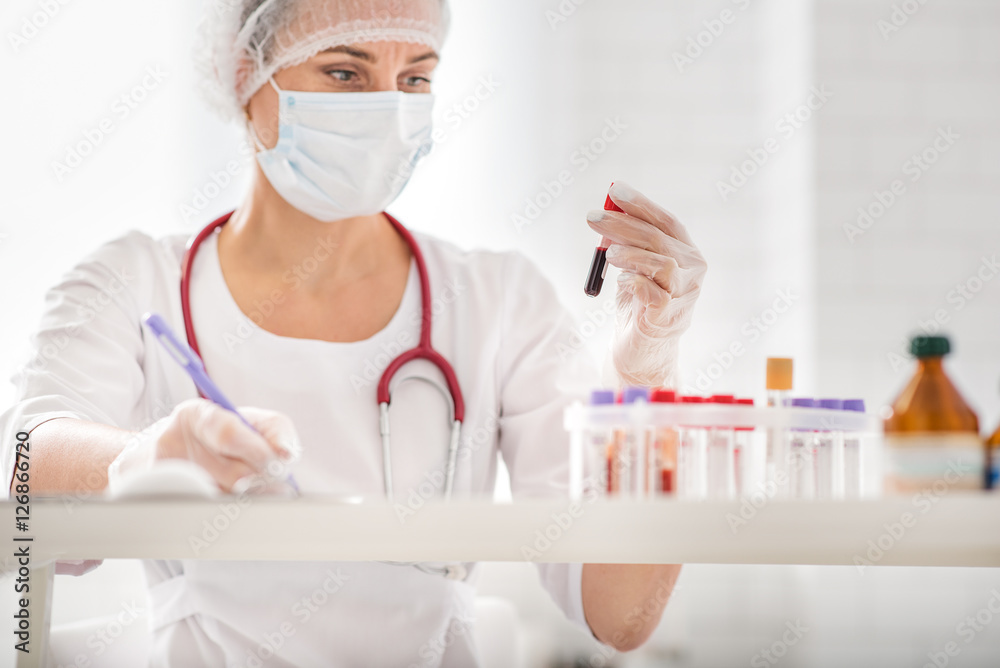 Busy doctor scrutinizing test tubes Busy doctor scrutinizing test tubes