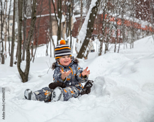 Child playing with snow in winter