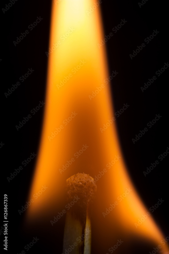 Burning match isolated on a black background, macro image. Burning match isolated on a black background, macro image.