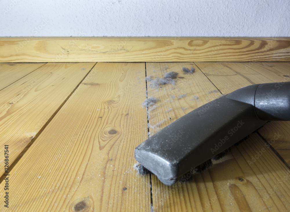 Dust dirt and crumbles on the wood floor under the bed. Home dust on the wooden floor.