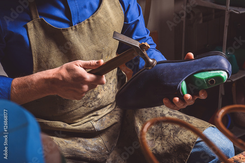 Canvas Print artisan holding a boot and hammer