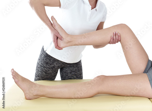 Doctor is stretching woman leg.