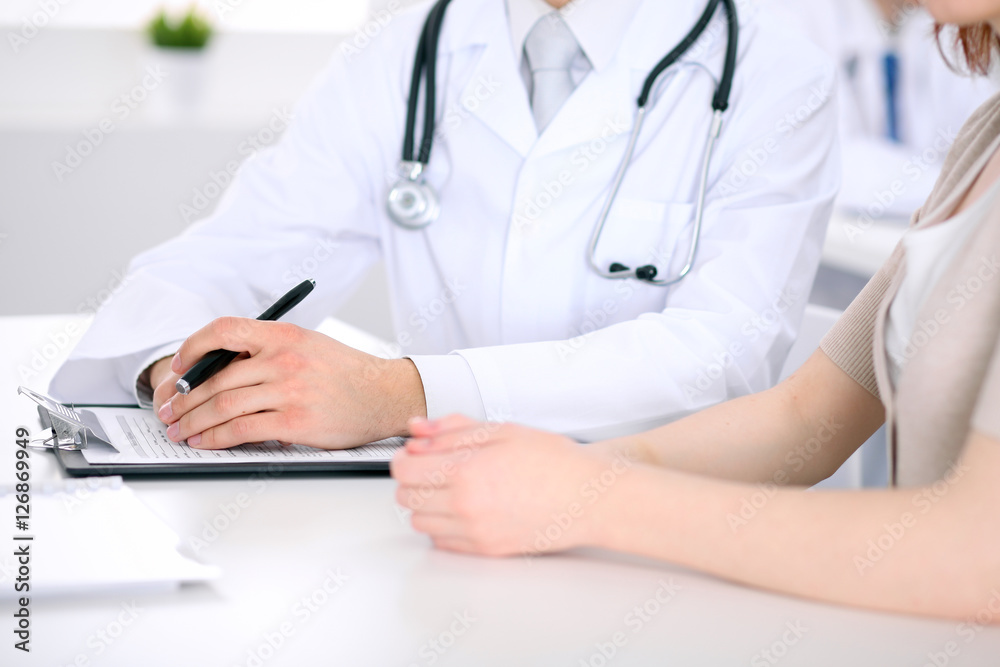 Doctor and patient are discussing something, just hands at the table Doctor and patient are discussing something, just hands at the table