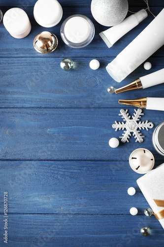 Beauty cosmetic products with Christmas decoration on blue wooden background
