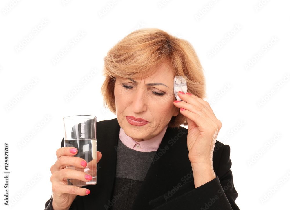 Portrait of senior woman suffering from headache and holding glass of water and medicines, isolated on white Portrait of senior woman suffering from headache and holding glass of water and medicines, isolated on white