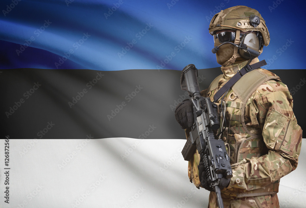 Fototapeta premium Soldier in helmet holding machine gun with flag on background series - Estonia