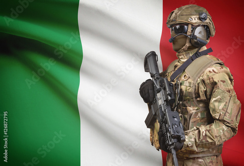 Soldier in helmet holding machine gun with flag on background series - Italy photo